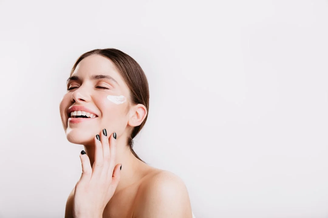 Close-up of a woman's glowing, even-toned skin alongside open serums and brightening skincare products arranged on a marble surface